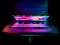 Leicht aufgeklappter Laptop im Neonlicht
