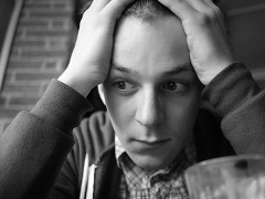 Junge hält verzweifelt die Hände vor den Kopf